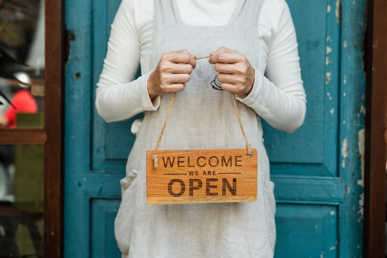 Person holding a welcome sign representing new member onboarding