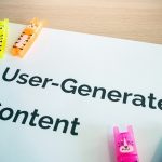User generated content concept desk with UGC sign representing member-created visual content in BuddyPress