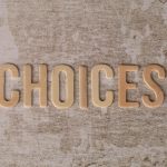 Wooden letters spelling choices representing the decision between WordPress forum plugins