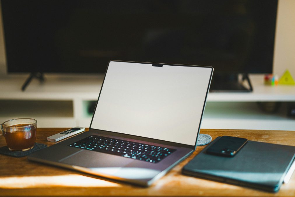 Laptop on wooden desk in home office workspace for community forum participation