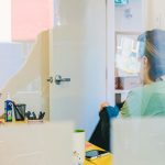 Woman working at desk through glass managing online community forum
