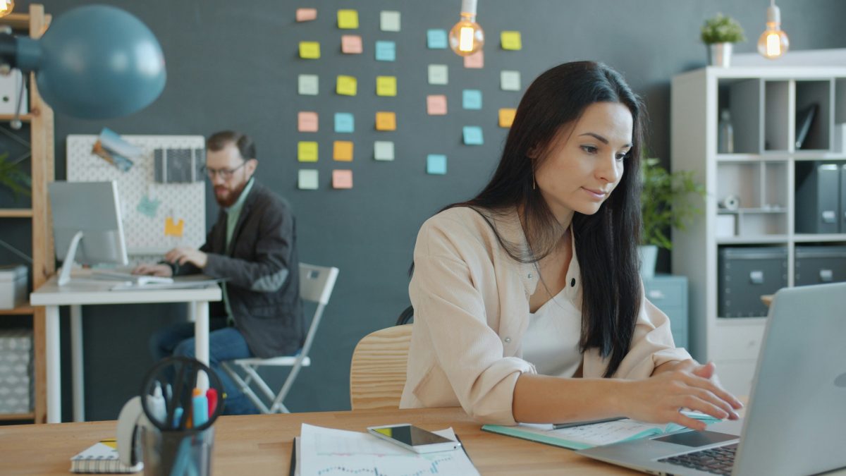 Businesswoman using laptop taking notes for community forum content management
