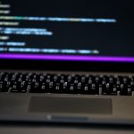 Laptop showing code on screen representing developer REST API integration for WordPress forums