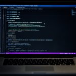 Laptop on desk with code representing SEO schema markup configuration for WordPress forums